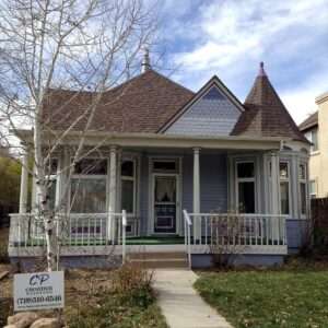 An older home painted with several colors and details.